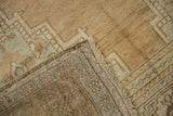Distressed vintage Oushak carpet's worn beige pile and tightly woven reverse foundation.