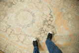 Close view of the distressed Oushak carpet's low pile, showing mostly even wear with sand and seafoam tones.