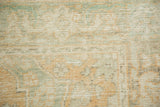 Mostly even wear revealing the hand-knotted texture in soft seafoam, terra cotta, and ivory.