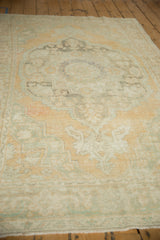 Angled view across the length of the distressed Oushak, highlighting its soft, low pile texture.