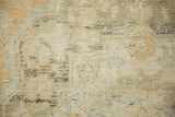 Close-up texture of the distressed Turkish Oushak, with low pile worn to the knot heads.