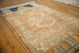 Time-softened tones and geometric pattern on the distressed Oushak rug border.