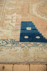 Vintage Oushak rug detail: geometric deep blue block and time-softened peach patterns.