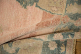 The hand-knotted pile and soft, pliable texture of a distressed vintage Oushak rug.