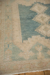 Distressed muted blue and pale coffee brown geometric patterns on vintage Isparta rug.