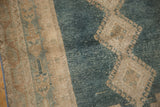 Distressed vintage Isparta rug texture featuring muted blue and faded beige geometric hook and latch motifs.
