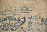 Distressed Anatolian rug showing geometric serrated leaves and vines in dusty blue and pale pink.