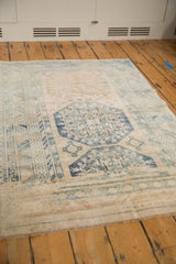 Worn blue guls and geometric borders on a distressed vintage Anatolian rug.