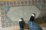A personal view of a distressed Oushak rug, showing its low-pile texture and scale.