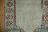 Evenly worn texture across the knot heads and floral border of a distressed Oushak rug.