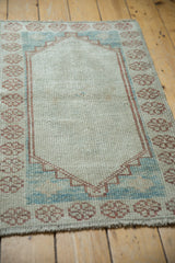 Angled view of the distressed Oushak rug showing its even wear and low pile texture.
