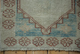 Close-up of a distressed Oushak rug's stepped corner spandrel and low-pile texture.