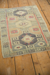 Angled view of a vintage Kars rug showing its distressed texture and geometric triple medallions.