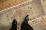 Distressed Oushak rug pile texture with faded geometric motifs and vibrant magenta accents.
