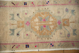 Vintage distressed Oushak rug close-up, geometric field pattern in beige, magenta, and slate blue.