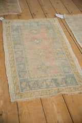 Vintage distressed Oushak rug mat with worn pile and soft blush, faded blue patterns.