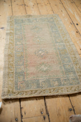 Distressed vintage Oushak rug's intact side selvage and faded blush, soft blue border.