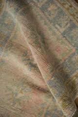 Distressed vintage Oushak rug pile, featuring faded blush and soft blue tones.