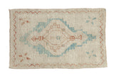 Distressed Oushak rug with a large geometric medallion in sky blue and copper on a textured ivory field.