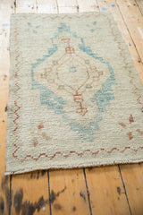 Low angle view of the distressed Oushak rug's nubby pile and meandering copper border.