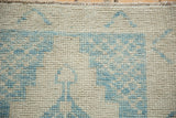 Detailed view of the distressed Oushak rug's even wear, revealing the ivory and blue knot heads.