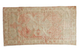 Vintage distressed Oushak rug with a faded diamond medallion in soft blush and ivory tones.