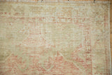 Short ivory fringe and worn hand-knotted pile on a distressed vintage Oushak rug.