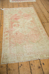 Angled view of a vintage Oushak runner showing its distressed texture and soft blush palette.