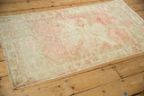The mostly even wear and faded rose design of a distressed Oushak runner.