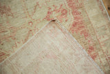 Hand-knotted foundation weave and machine-bound edge of a distressed Turkish Oushak rug.