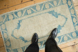 Overhead view of a distressed Oushak rug, showing its scale and worn, nubby texture.