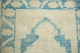 The even wear and hand-knotted texture of a distressed Oushak rug in sky blue and ivory.