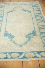 The soft, distressed texture of a vintage Oushak rug in sky blue and ivory, showing the low hand-knotted pile.