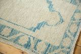 Even wear and low pile texture of a distressed Oushak rug in ivory and sky blue.