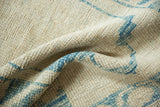 Close-up on the even wear and texture of a distressed Oushak rug's hand-knotted pile.
