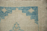 Detail of the sky blue stepped corner spandrel showing the even, low-pile hand-knotted texture.