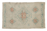 Distressed Oushak rug with a central diamond medallion in copper and powder blue on a platinum field.