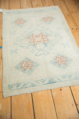 Angled view of a distressed Oushak rug highlighting its even wear and low, textured pile.