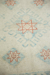 Evenly worn knot heads on a distressed Oushak rug with geometric copper starburst designs.