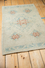 Distressed Oushak rug viewed at an angle, showing the even wear and textured surface.