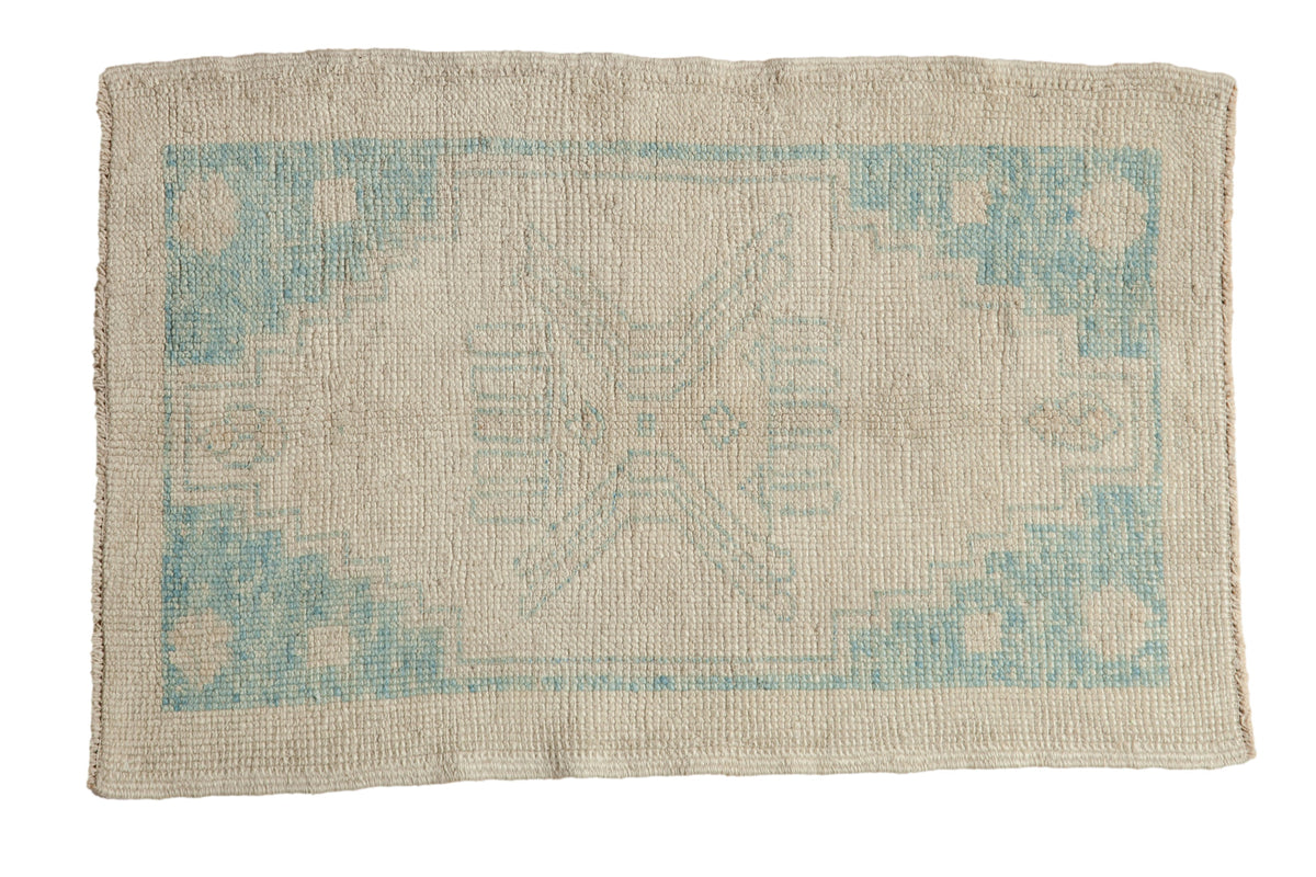 Distressed Oushak rug features faded sky blue stepped medallion on an ivory field, 2'5" x 3'9".