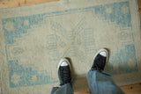 Distressed Oushak rug texture, showing faint foundation and powder blue blossom motif.