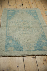 Distressed Oushak rug's texture, showing faint foundation through powder blue pattern and intact selvage.