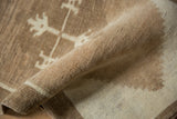 Rolled vintage Kars rug edge, displaying short even pile and tightly woven natural foundation.