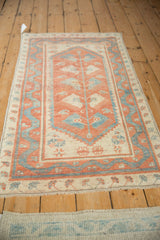 Angled view of a distressed Oushak runner, showing the meandering border and central design.