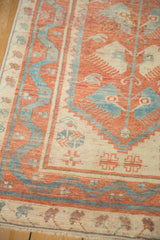 Distressed texture and corner view of an Oushak rug's sky blue serpent border.