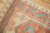 Close view of the machine-bound corner of a Turkish Oushak rug with brick red and sky blue borders.