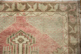 Visible knot heads on the lattice corner of a distressed vintage Oushak rug in faded red.