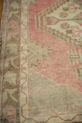 Visible knot heads and low pile texture on a distressed Turkish Oushak rug in faded cherry red.