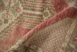 Worn hand-knotted pile and woven back of a vintage distressed Oushak rug in faded red.
